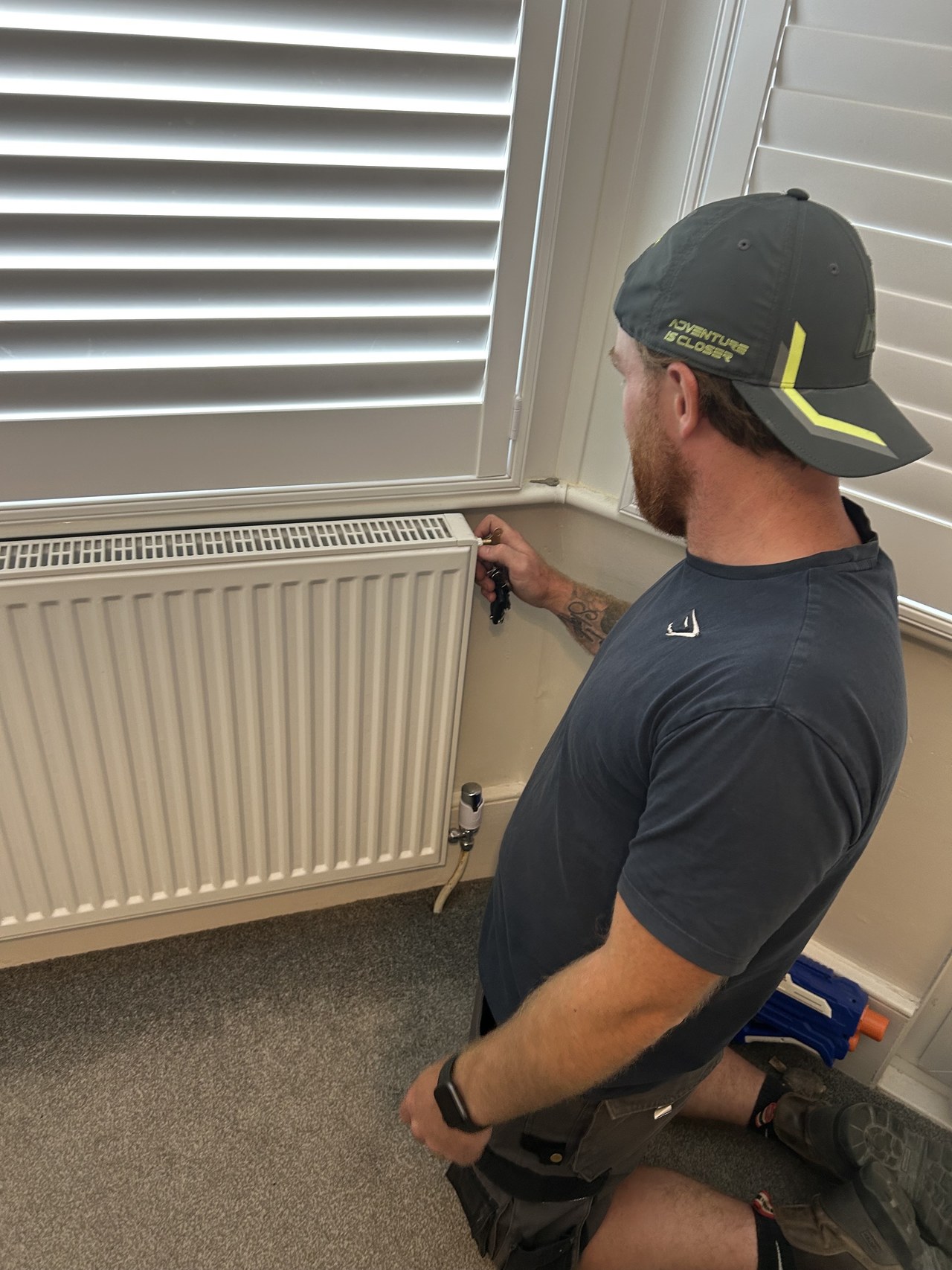 Anthony from Mongan Plumbing and Heating working on a radiator