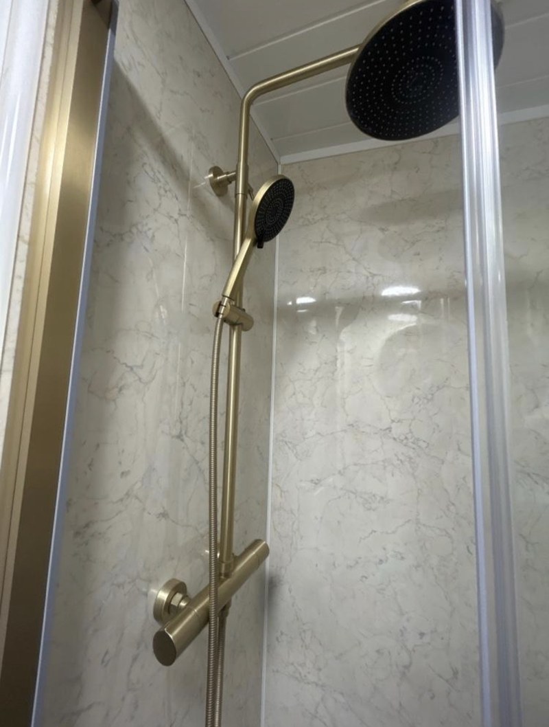 Brushed brass thermostatic shower fitted in a bathroom