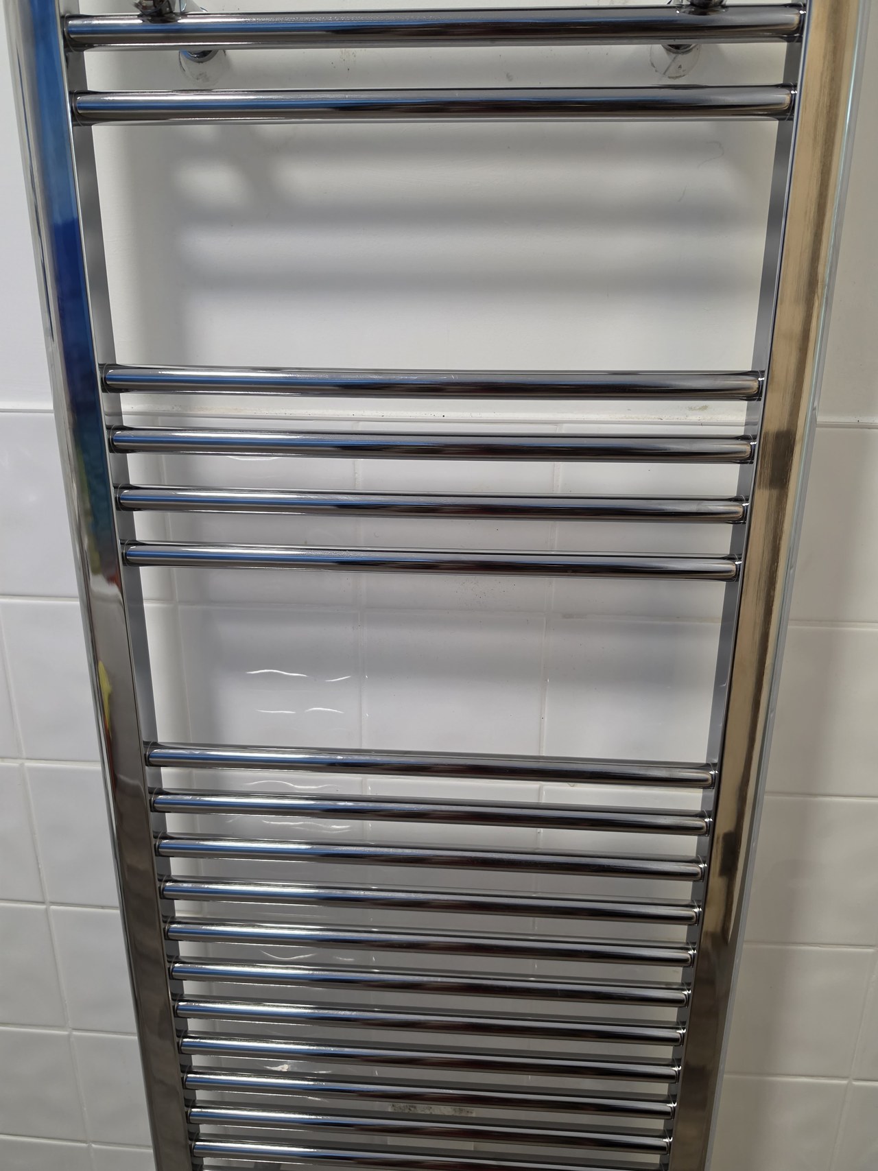Chrome heated towel rail fitted in a bathroom