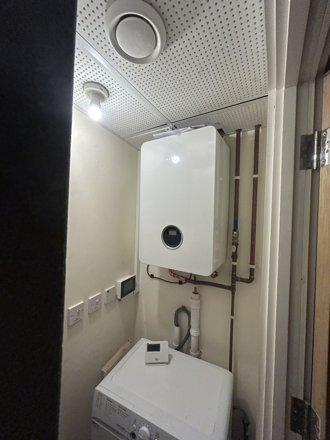 Heating unit in a cupboard with tidy pipework