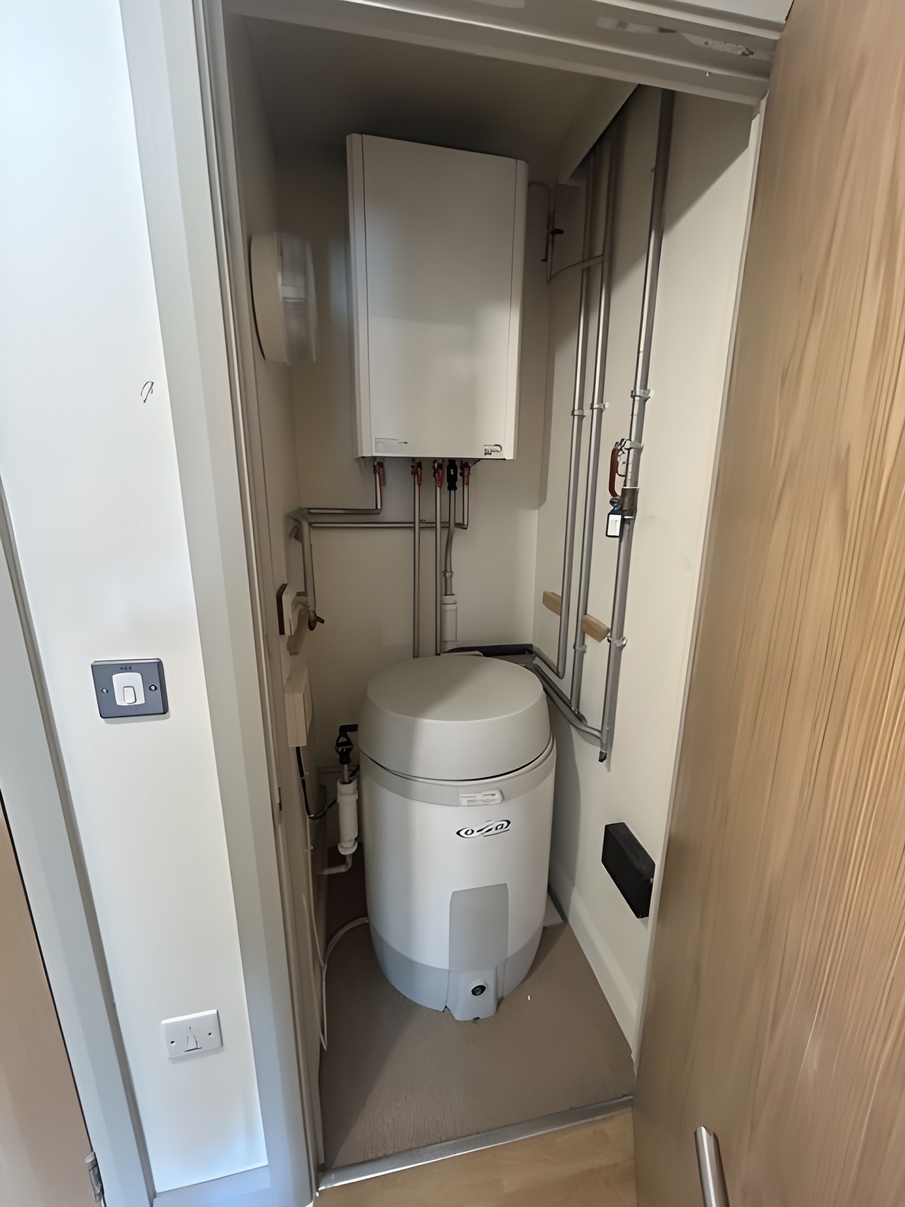 Hot water cylinder and heating unit in a cupboard